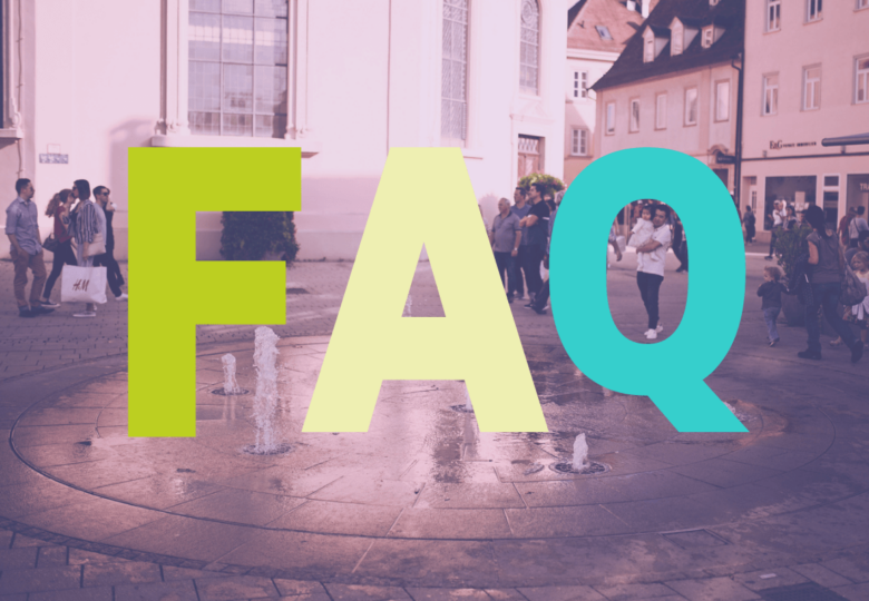 Das Bild zeigt die Asperger Straße in Ludwigsburg. Im Vordergrund befinden sich drei farbige Buchstaben: FAQ